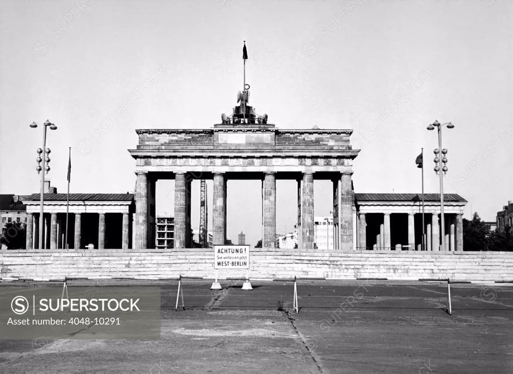 The Brandenburg Gate in East Berlin behind the Berlin Wall. A sign in German warns of the border between East and West Berlin. Aug. 13, 1965.