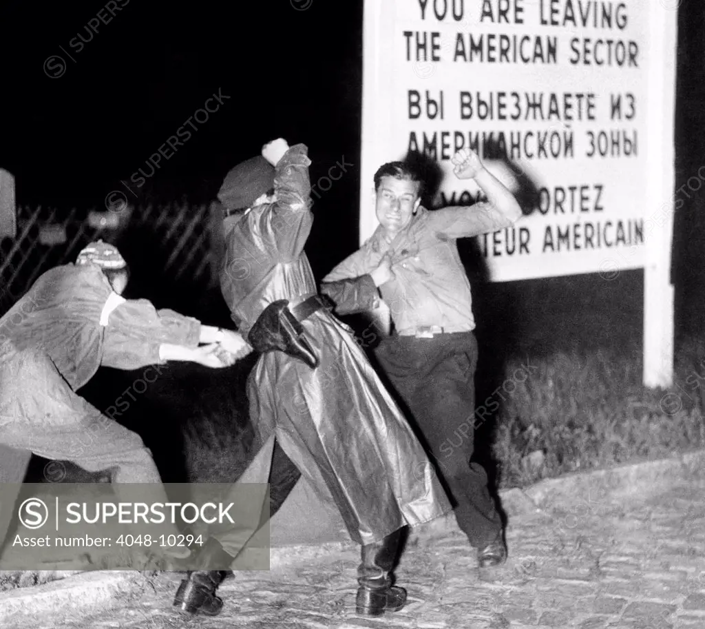 Violent clash between an East German policeman and his accomplice (left) as they seize a youth who tried to flee across the border into the American sector of West Berlin. Ca. March 20, 1952.