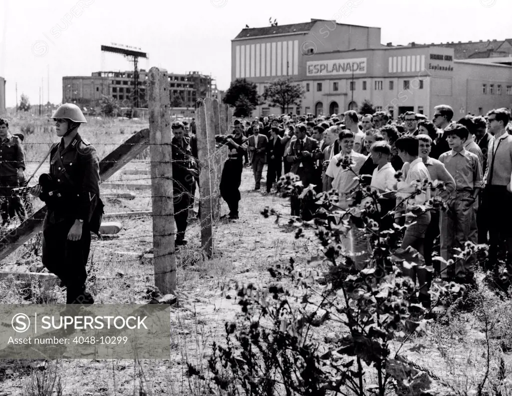 First Days of the Berlin Wall. West Berliners jeer East German soldiers patrolling the new barbed wire barricades closing streets between the Russian occupied sector and the French, British and U.S. zones. August 13, 1961.