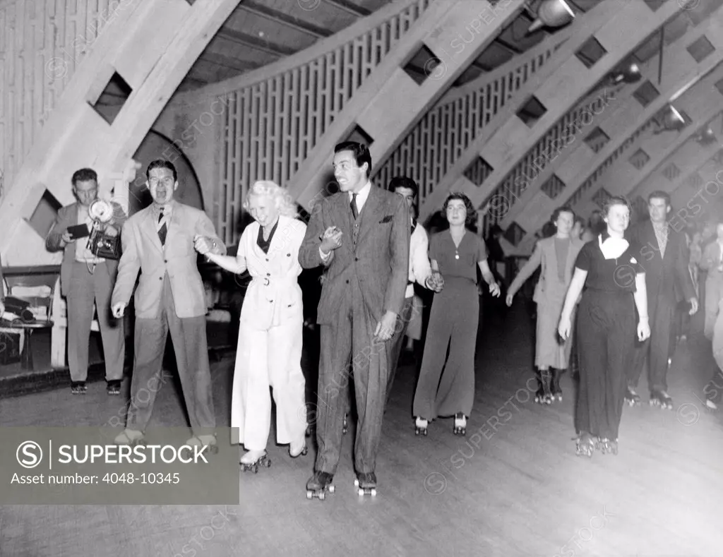 Hollywood stars and socialites at roller-skating party at Roller-Dome in Culver City. L-R: Tom Brown, Toby Wing, and Ceasar Romero. June 6, 1936.