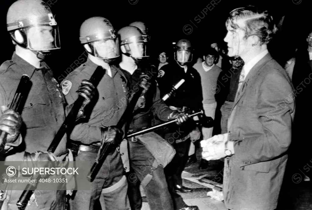 Terence Hallinan, an activist attorney, bloody from a gash in his head, confronts the police officer who clubbed him. The incident took place when police broke up a sit-in at San Francisco State College. May 21, 1968. Hallinan was a crusading lawyer, who engaged in civil disobedience and defended hated criminals.