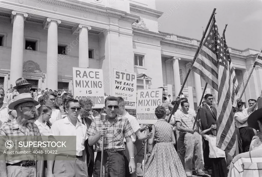 Segregationist rally in Little Rock. Whites holding signs protesting against 'Communist race-mixing' on the steps of the State capitol. Little Rock, Alabama, Aug. 20, 1959.