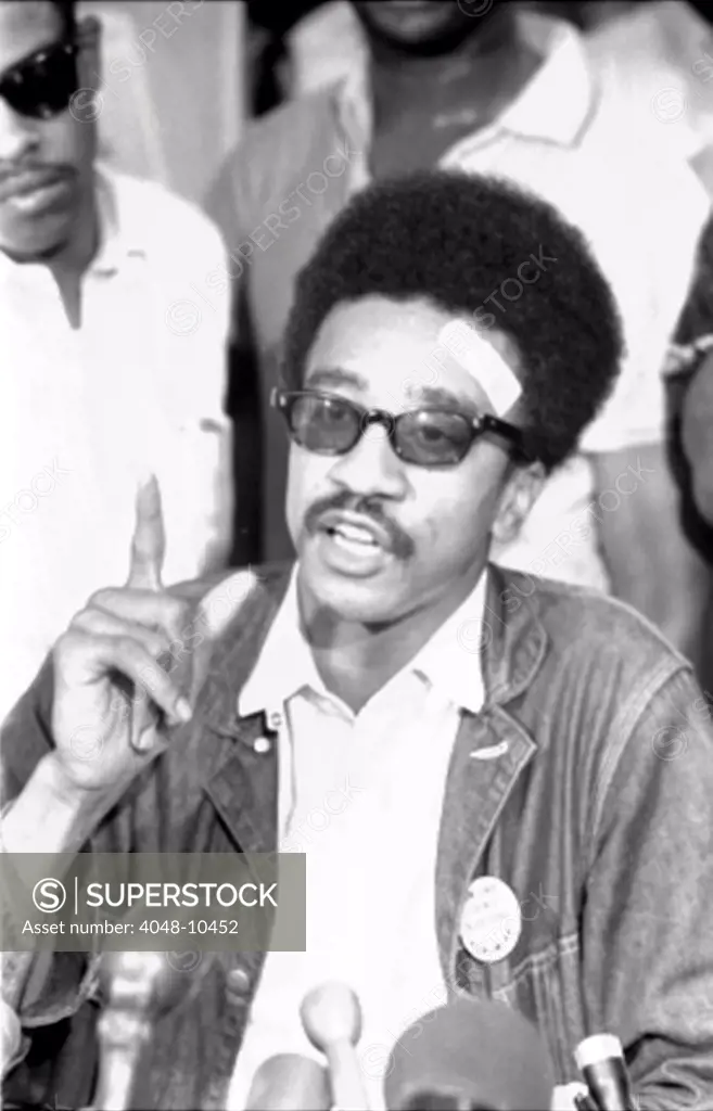 H. Rap Brown, chairman of the Student Nonviolent Coordinating Committee (SNCC) holding a news conference on July 27, 1967. His militant rhetoric provoked a criminal charge of inciting riot in Cambridge, Maryland. He made the FBI's Ten Most Wanted List when went underground avoid prosecution.