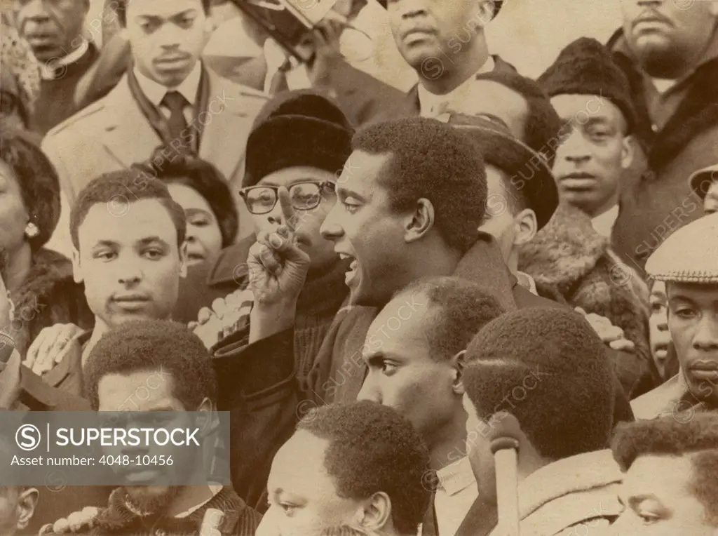 Profile of Stokely Carmichael speaking and gesturing in midst of crowd demonstrating near the Capitol in Washington, DC. January 10, 1967.