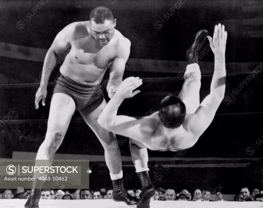 Joe Louis throws Jim Bernard to the mat during a 1956 wrestling match at Olympia Stadium in Detroit. At age forty, Louis took up professional wrestling to earn money to pay back taxes.