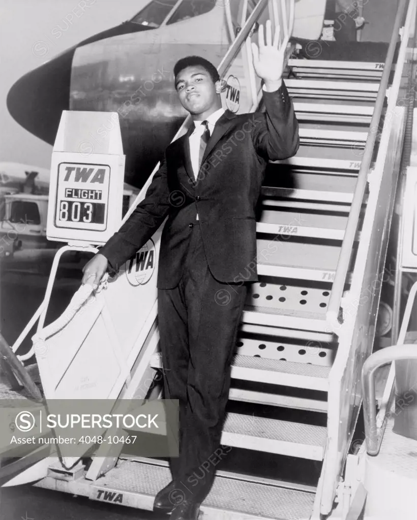 Muhammad Ali, waves from the steps of a TWA airplane at JFK International Airport in New York. 1964.