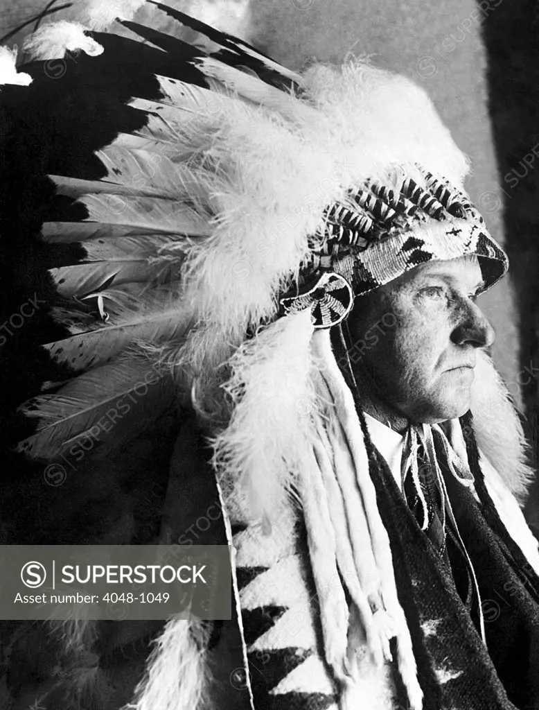 President Calvin Coolidge wears a headdress presented to him by the Sioux Indians, 1927
