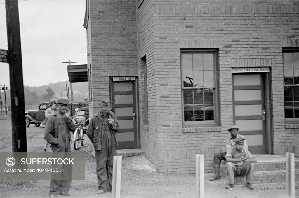 Colored Waiting Room sign. Four African American men stand outside of the Manchester, Georgia, railroad station. May 1938.