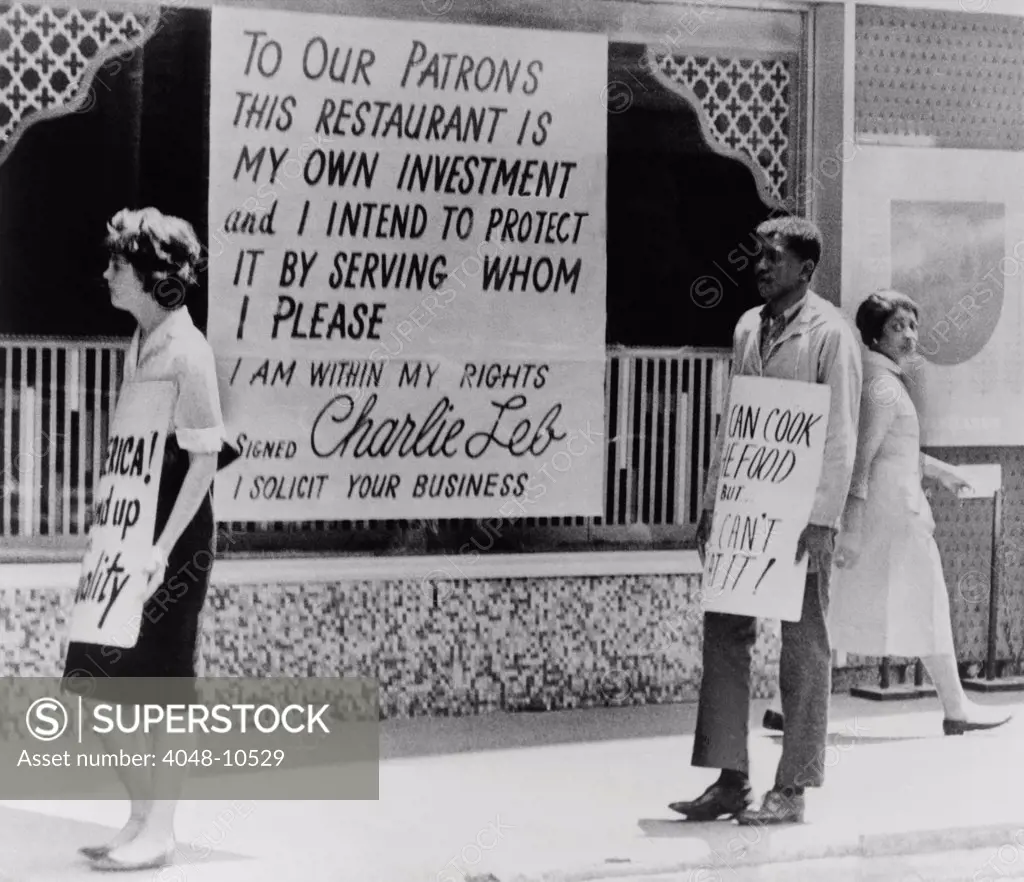 People picketing outside an Atlanta restaurant which displays a segregationist sign. 1963.
