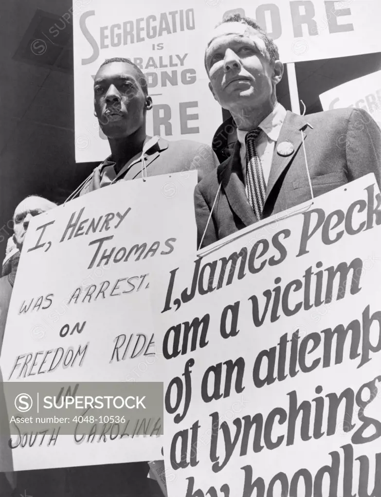 Freedom Riders James Peck, head bandaged, with Henry Thomas, each wearing a placard, picketing outside the New York City Port Authority Trailways bus terminal. May 17, 1961.