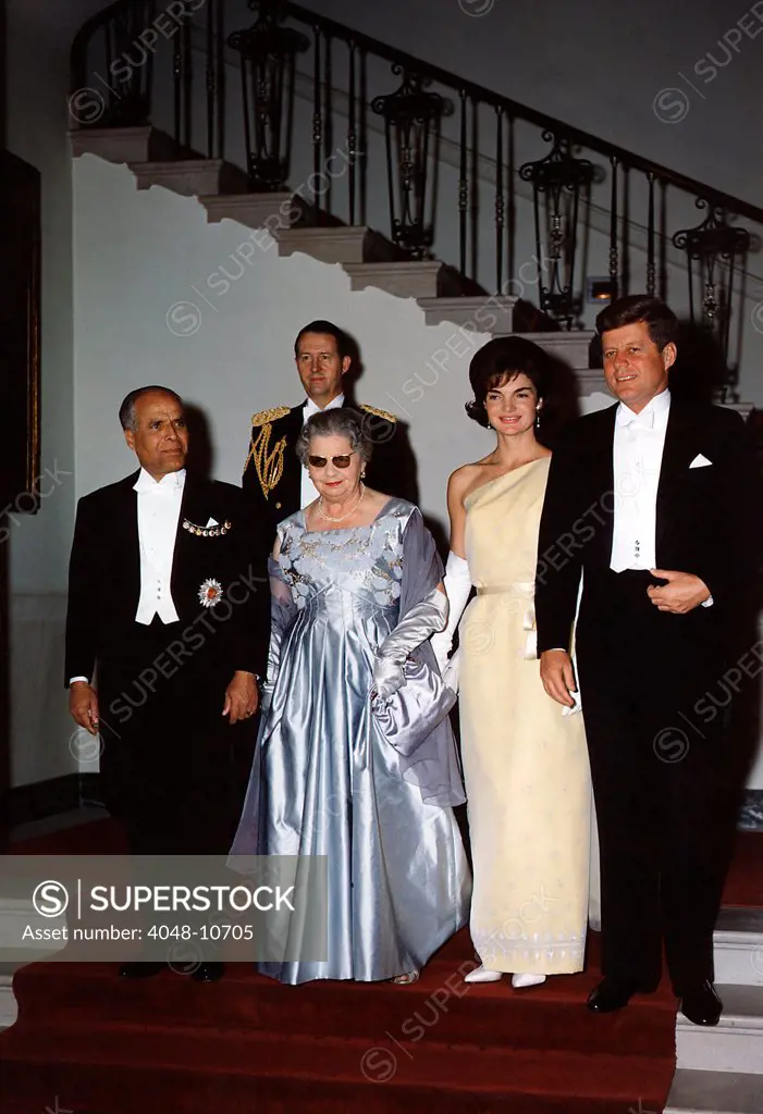 White House state dinner quests at Grand Stair Case. L-R: Tunisian President Habib Bourguiba, Mrs. Bourguiba, Jacqueline Kennedy, President Kennedy. Behind the group is General C.V. Clifton. May 4, 1961.