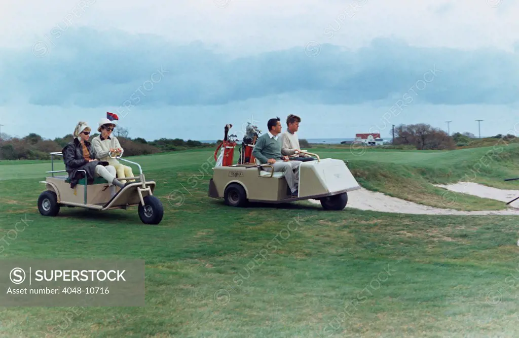 The Kennedys golf with the Ben Bradlees at the Newport Country Club. Antoinette Bradlee and Jacqueline Kennedy follow the golf cart of the President and Journalist Benn Bradlee. Sept. 14-15, 1963.