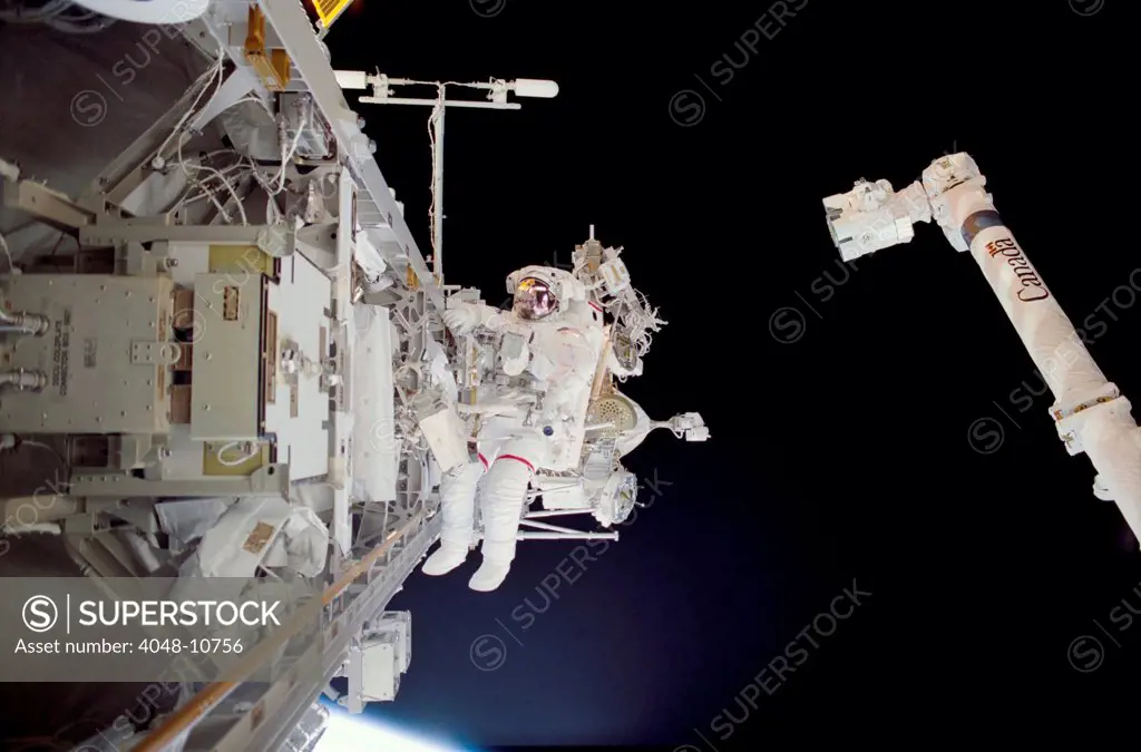 Construction work on International Space Station. Astronaut Michael Lopez-Alegria in a space walk near the Canadarm while assembling the International Space Station's backbone. Nov. 30, 2002.