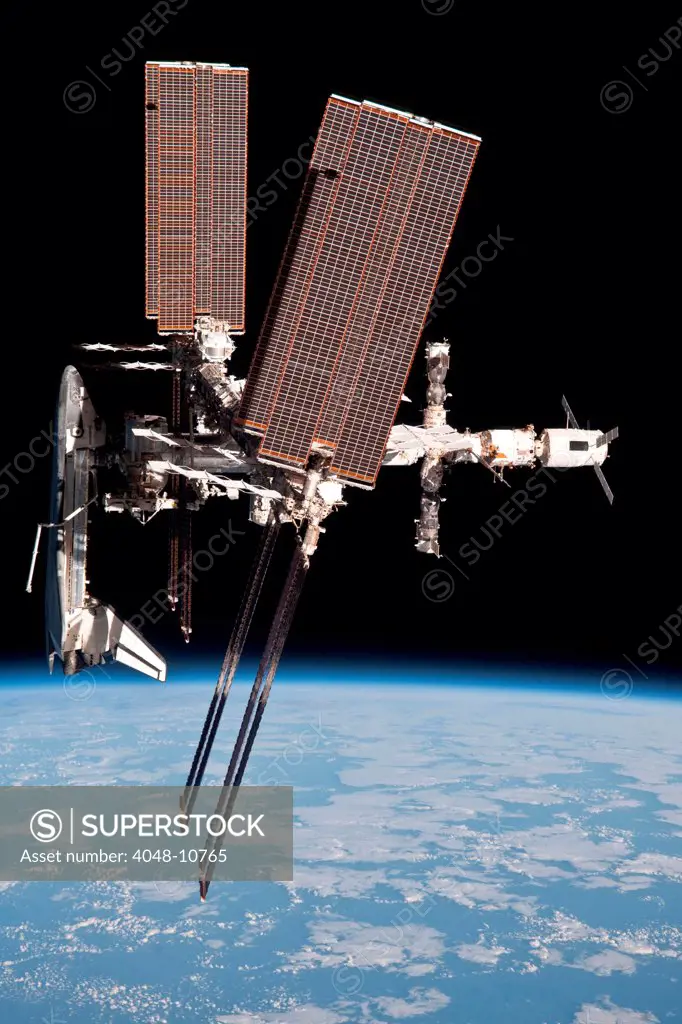 Space Shuttle Endeavor docked to the International Space Station. Photo taken from a departing Soyuz spacecraft, whose crew completed a 159 day space mission. May 23, 2011.