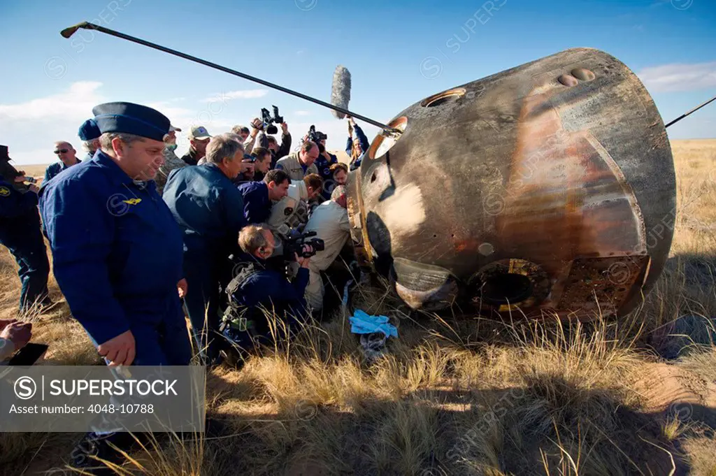 Soyuz TMA-21 spacecraft shortly after the capsule landed in Kazakhstan. The Russian land crew begins to open the heat scorched capsule containing International Space Station Expedition 28 crew. Sept. 16, 2011.