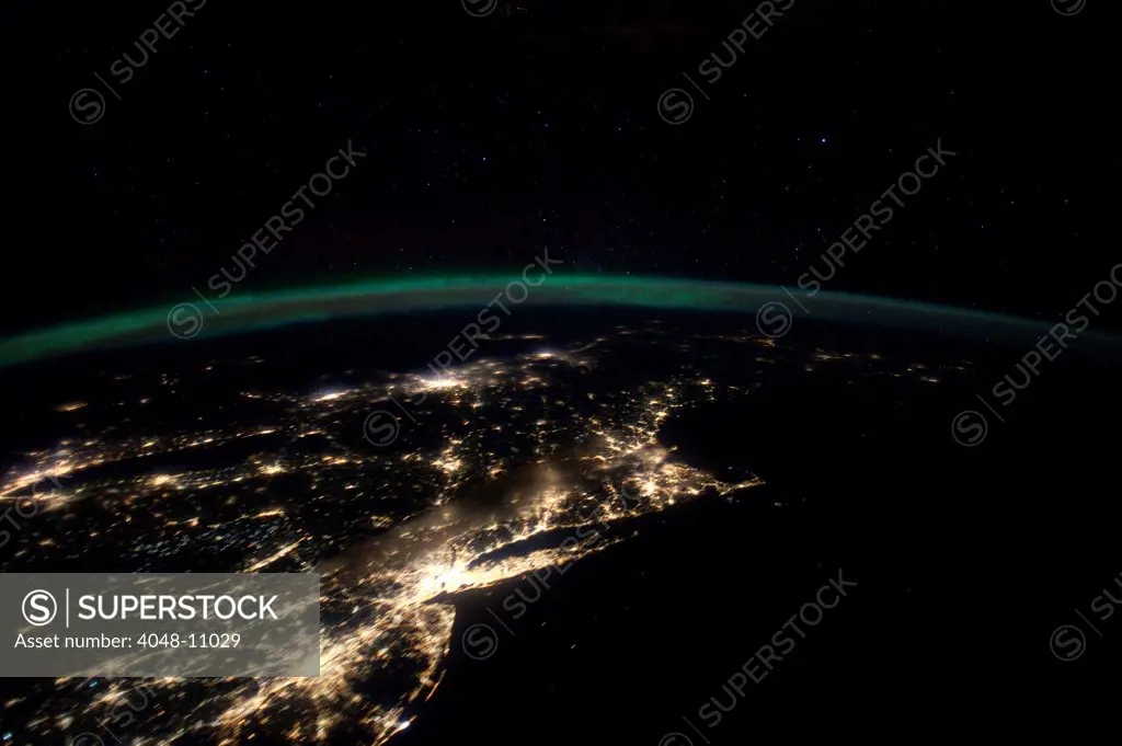 Night lights from the Philadelphia-New York City-Boston corridor. At left is western Lake Ontario shoreline with Toronto , Montreal is at near center.  The atmospheric limb and light activity from Aurora Borealis appear intertwined. Jan. 29, 2012.