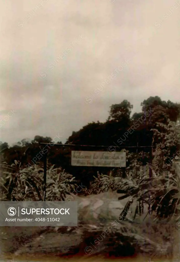 Front Gate Welcome Sign and gate at the beginning of the road into Jonestown. People's Temple Agricultural Project. Jonestown, Guyana. Nov. 1978.
