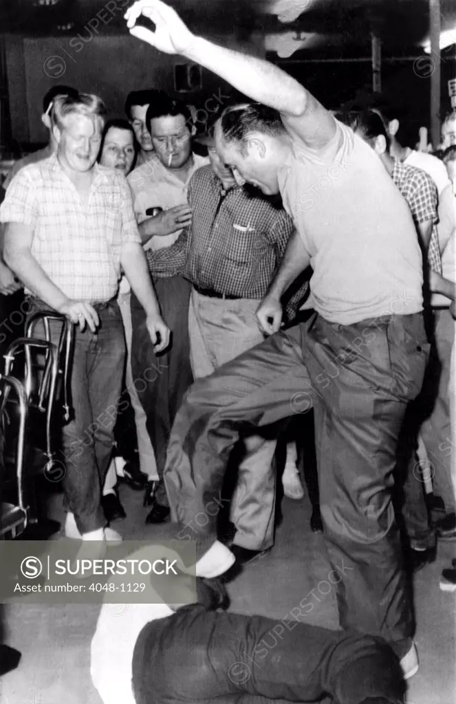 Jackson, Mississippi: 21-year-old Memphis Norman is beaten by a man identified as Benny Oliver, a former policeman, 5/28/63, after being dragged from a lunch counter stool during a sit-in demonstration at the counter.