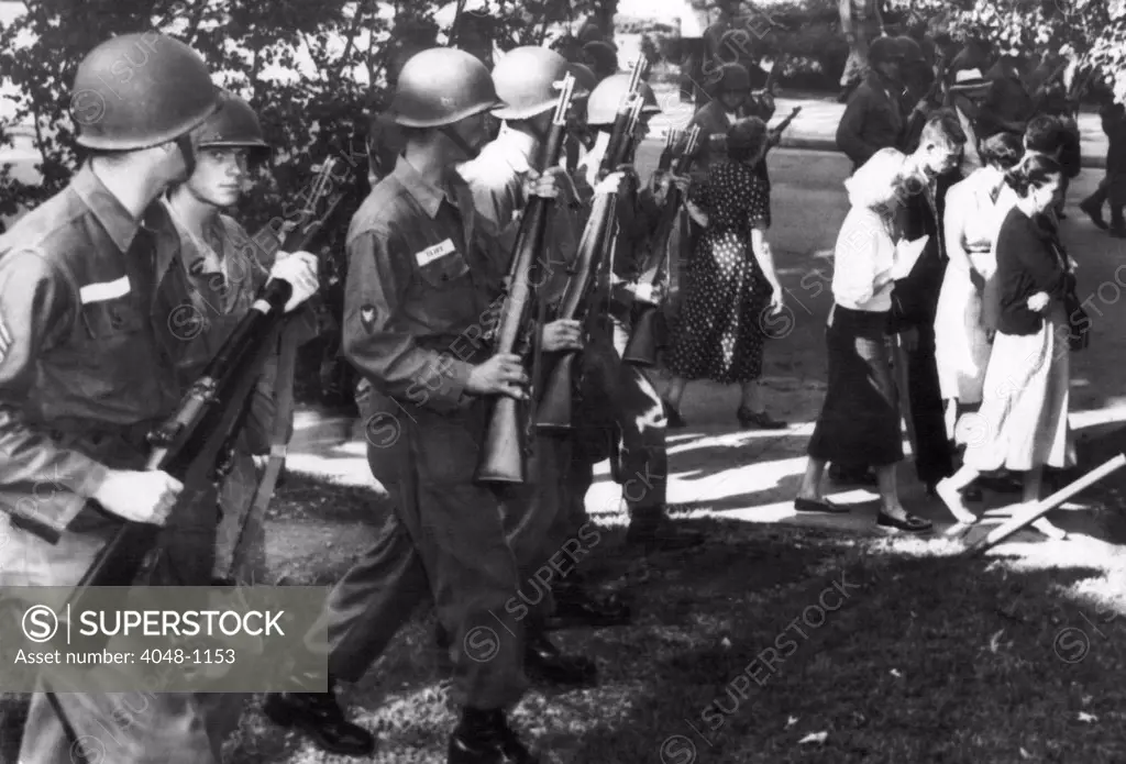 Troopers order parents and students who joined a protest march at Central High School in Little Rock, Arkansas to move away from school grounds. They were protesting the attendance of nine black students at the school, 1957