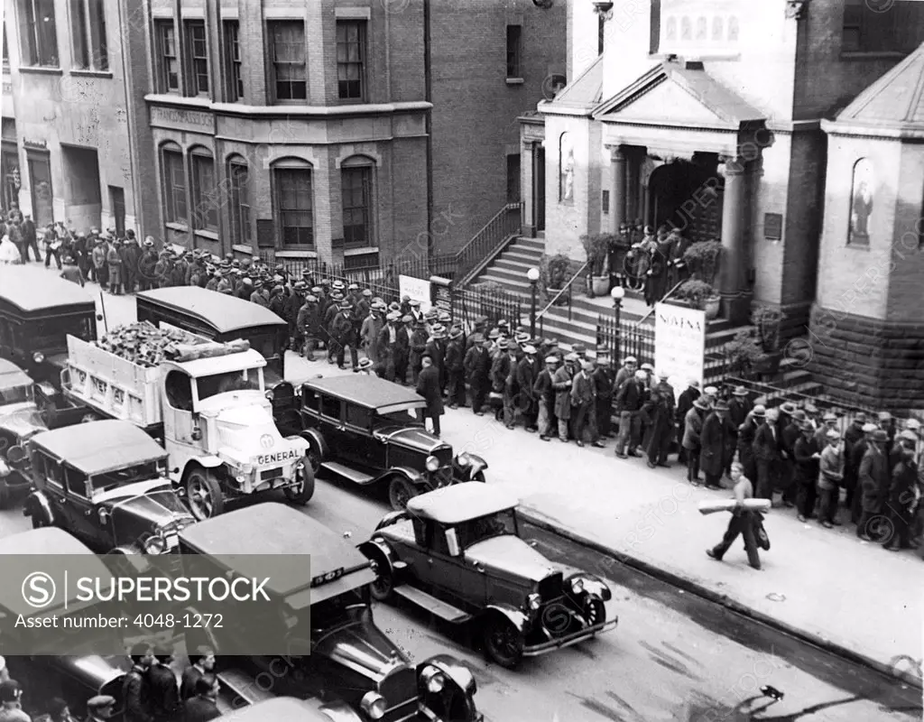 DEPRESSION- Jobless men lined up in front of St. Francis of Assisi Church waiting to receive a nickel each from Father Gabriel. New York, 1930s