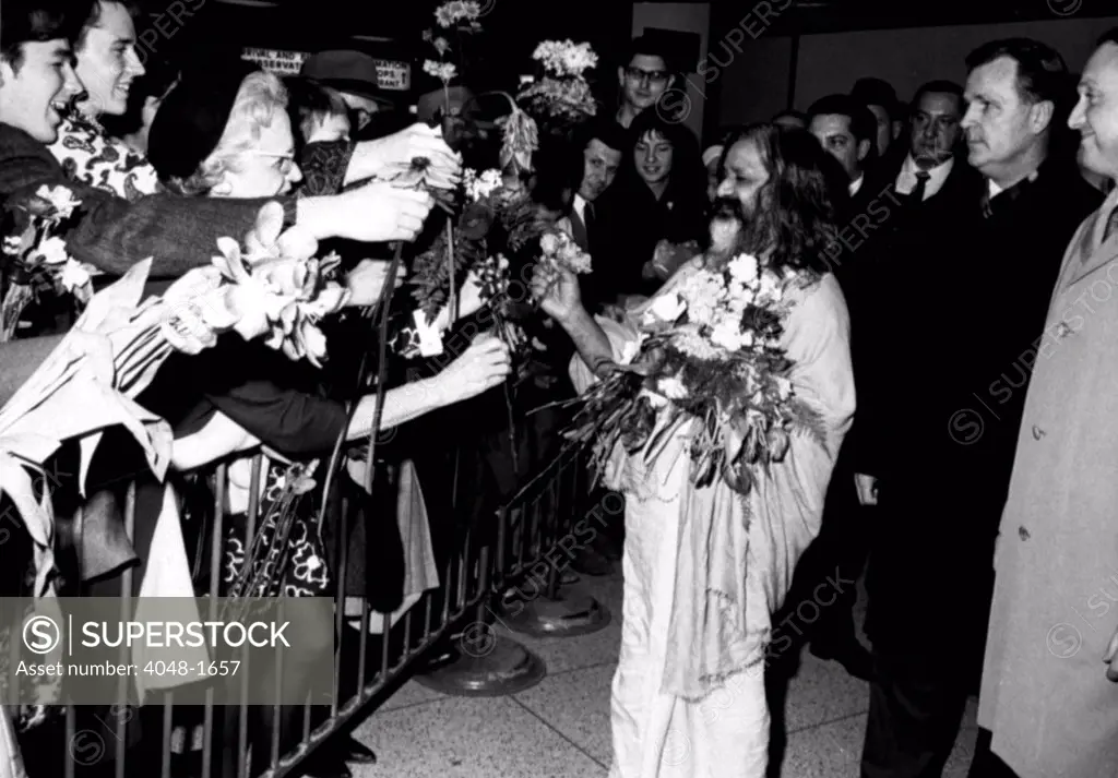 MAHARISHI MAHESH YOGI, head of the spiritual regeneration movement, accepts flowers from his followers, greeting his arrival at a NY airport,  January 18, 1968
