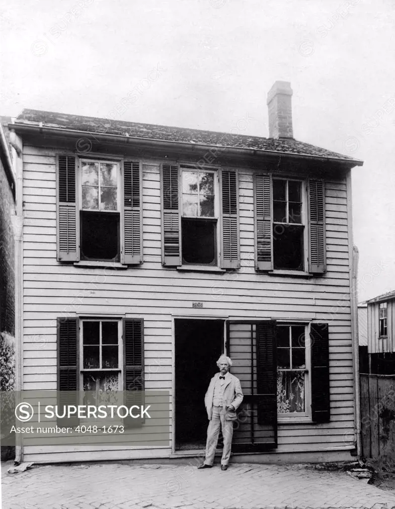 MARK TWAIN in front of his boyhood home in Hannibal, Missouri. Undate photo.