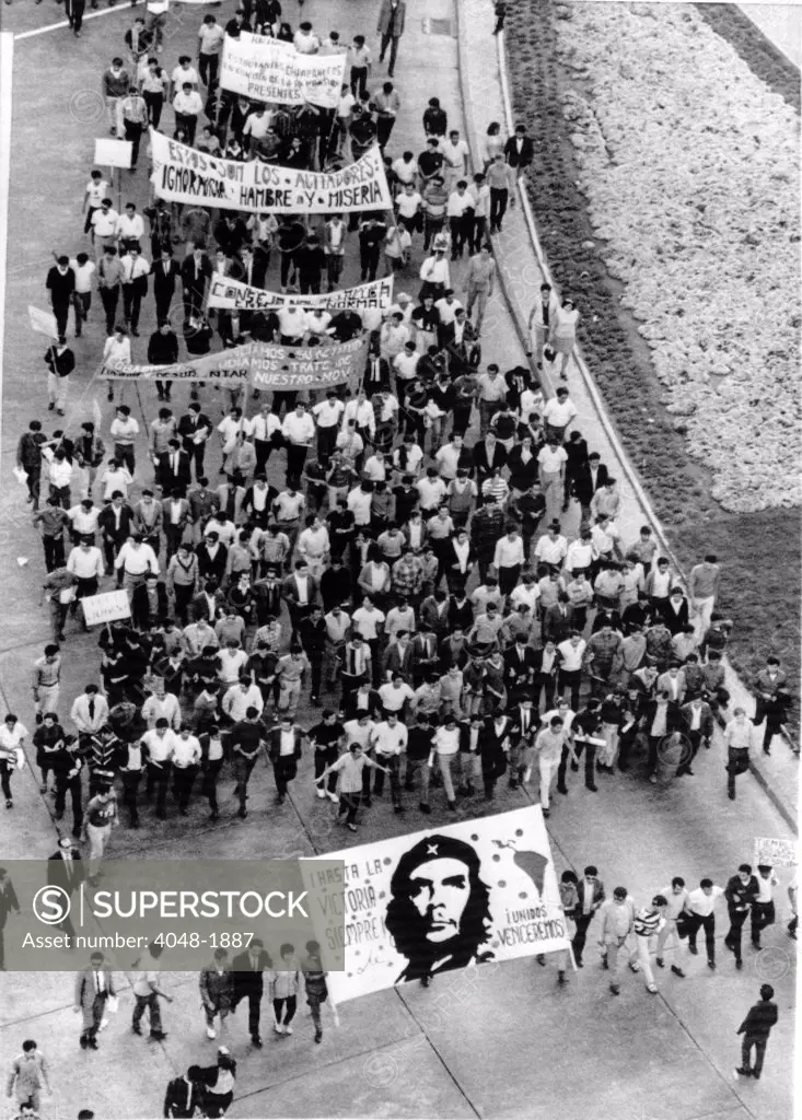 Mexico City: Students stream along Mexico City's Reforma Blvd en route to the Presidential Palace, carrying a banner bearing Che Guevara's portrait.  August 13, 1968.