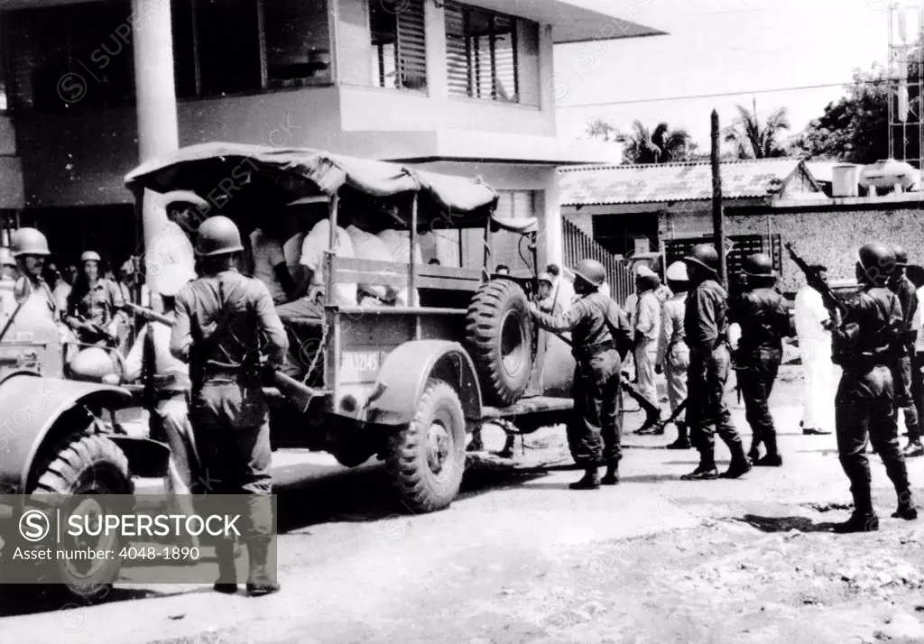 Aculpulco, Mexico: Mexican Army troops escort alleged ambushers out of cocnut growers' union hall after a shooting incident in which at least 23 people were killed, August 21, 1967