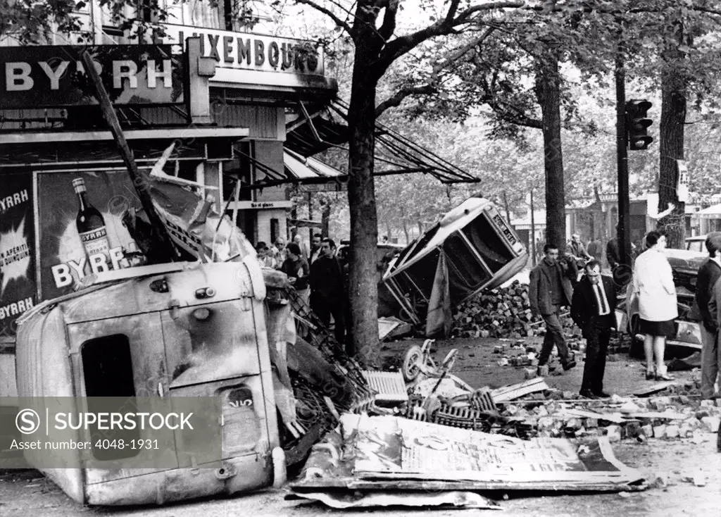 RIOTS-Parisians inspect overturned auto and other debris in the Edmond Rostand Square after riot. 5/25/98