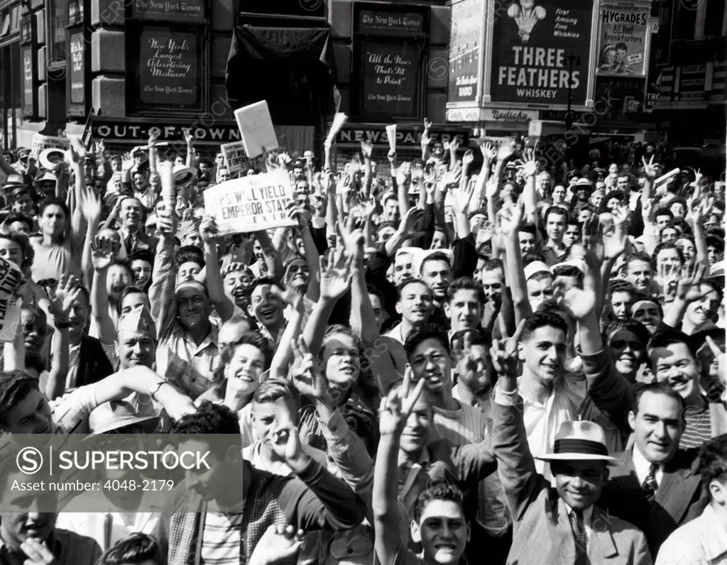 New Yorkers celebrating VJ Day and the prospect of an end to World War II, Times Square. The newspaper headline reads: 'Japs Will Yield If Emperor Stays', August 1945.