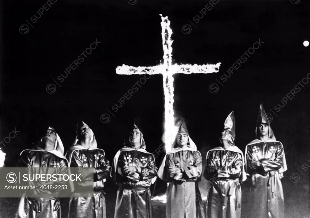 9/5/71--STONE MOUNTAIN, GA: Six unidentified Ku Klux Klan members in front of the traditional burning cross at a rally billed as a nationwide rally near Atlanta 9/4. A crowd of several hundred whites heard speakers denouce school busing, the Supreme Court, Red China and the United Nations.