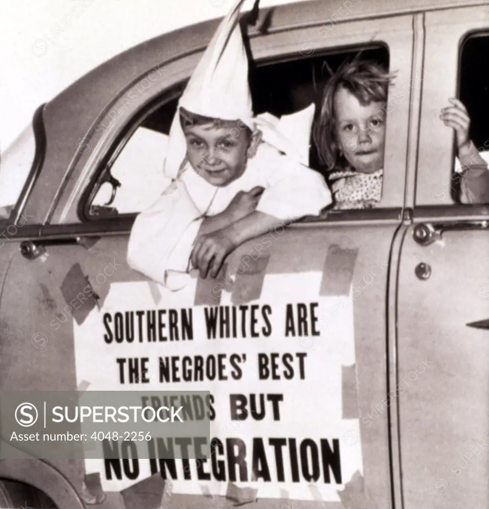 4/14/56--MACON, GEORGIA: Perry Blevens, age 7, all decked out in his Ku Klux Klansman robes, rides in the motorcade staged here by the KKK 4/14/. With Perry is Sherley Ann Bowman of Bwinett County, Georgia.