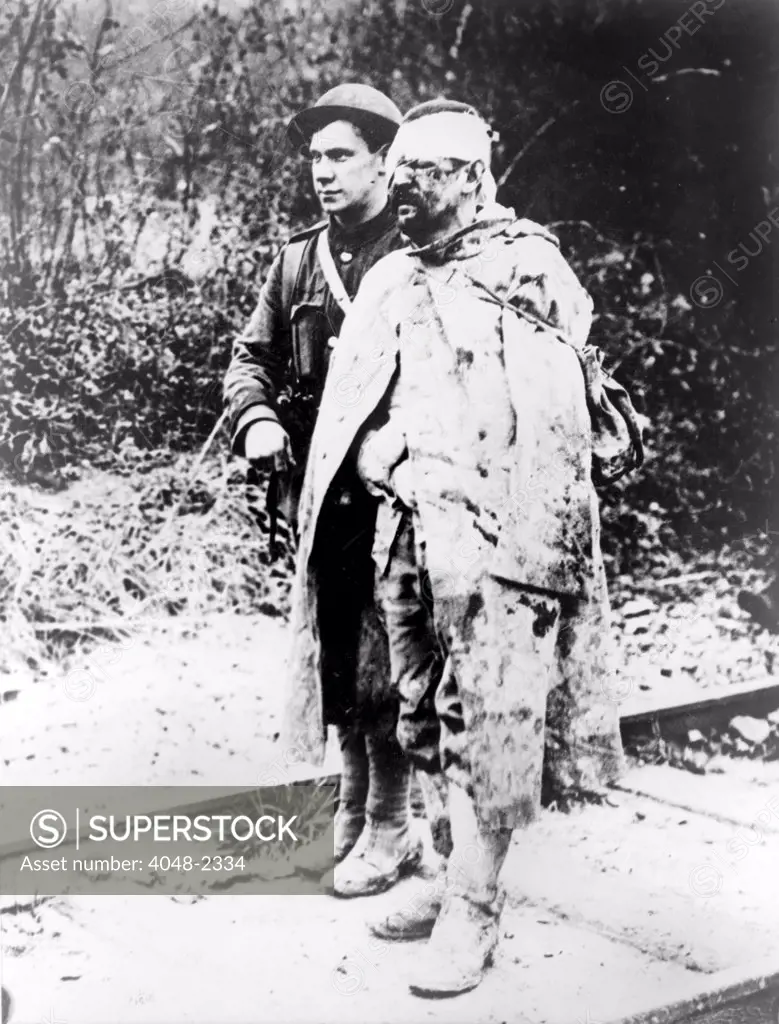 World War I, Another sort of war ruin - after several days in the trenches, a British Red Cross orderly escorting a wounded, captured German soldier to a field hospital for treatment, 1914-1918.