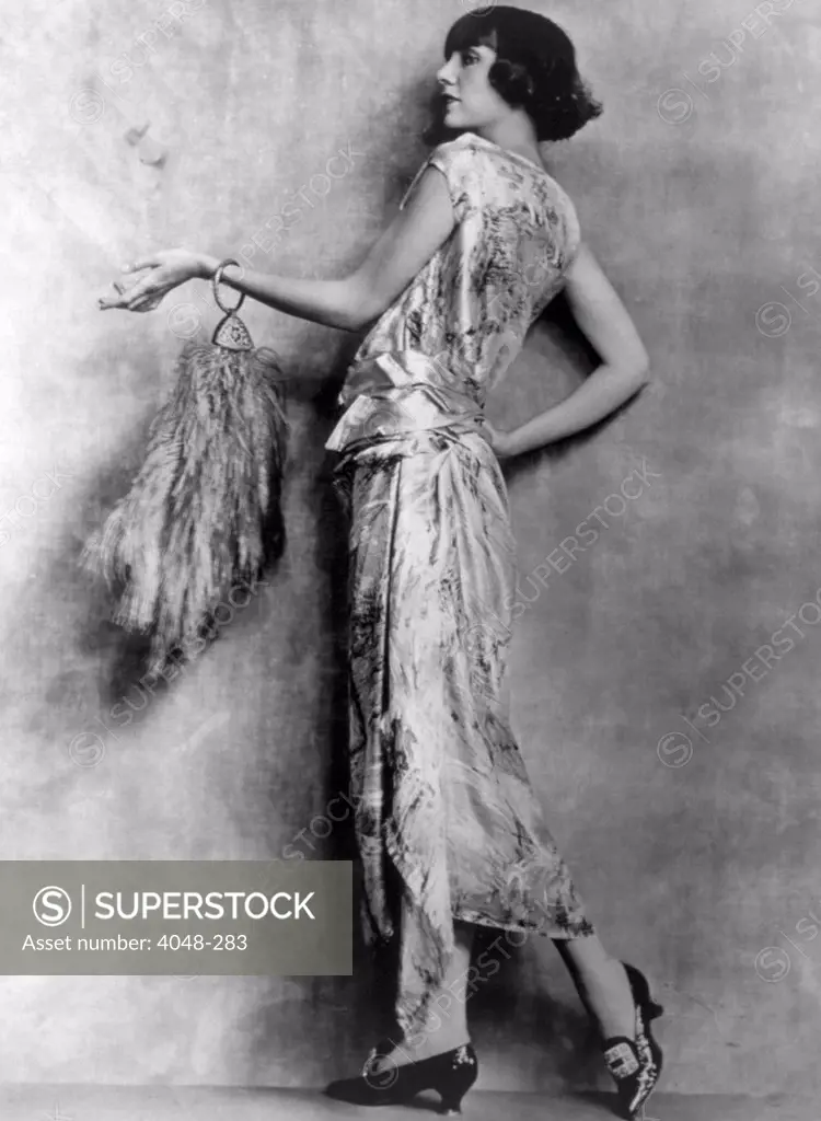 Evening gown of brocaded satin and feathered handbag, circa 1922. Photo: Courtesy Everett Collection