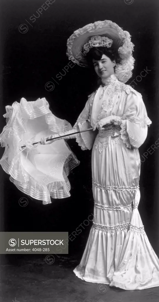 Woman wearing an 1890s dress and parasol; photo taken 1915. Photo: Courtesy Everett Collection