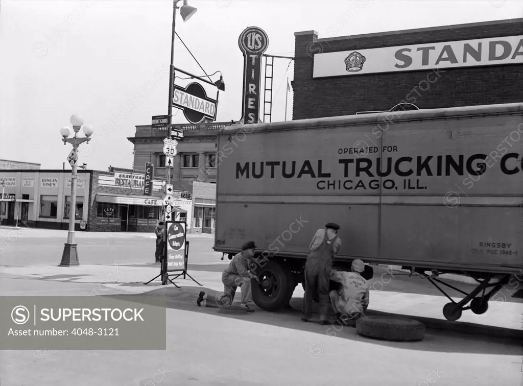 Nebraska, changing a tire on a trailer truck, Kearney, photograph by John Vachon, Omaha, May, 1942.