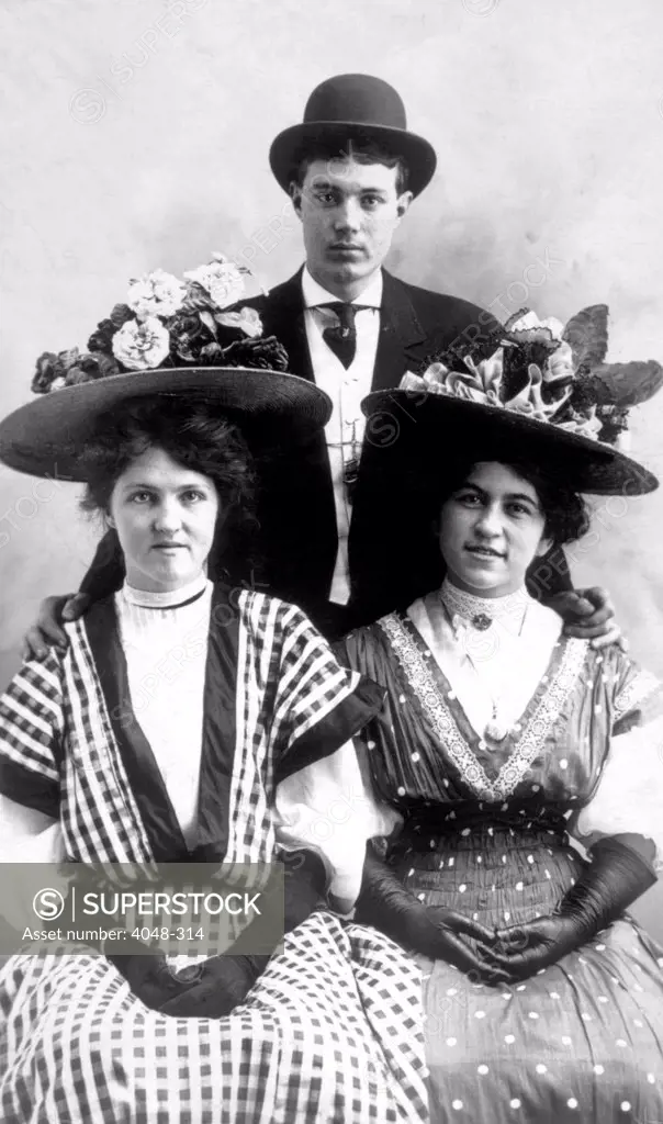 Two women and a man wearing hats, circa 1909. Photo: Courtesy Everett Collection