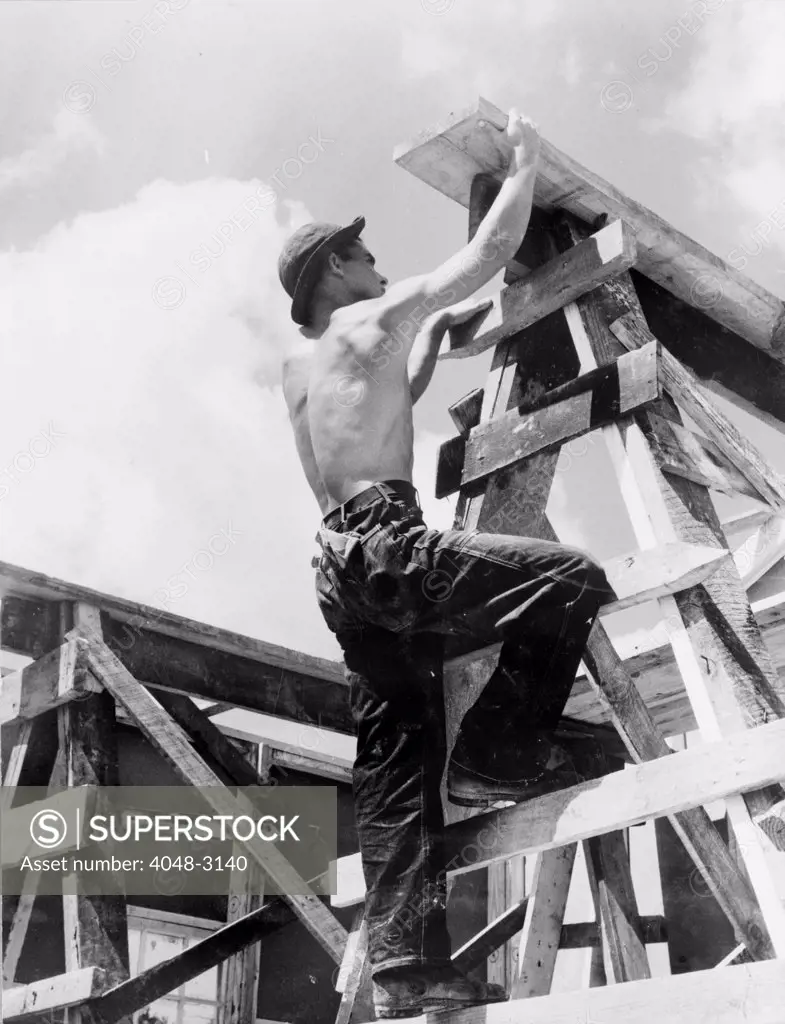 Civilian Conservation Corps at work. Enrollee William L. Cross climbing up on a scaffold erected for assembling a prefabricated building to be a camp work shop, United States Resettlement Administration, Appalachia, Virginia, 1935-1942.