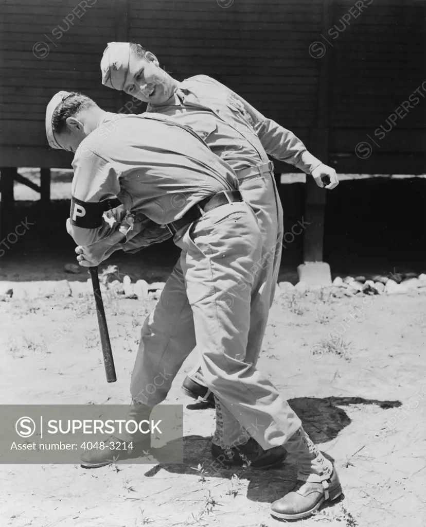 World War II, Private Melvin Kearney, and Military Police Private Elliott Schneiderman (front), practicing disarming a club man, circa 1942.
