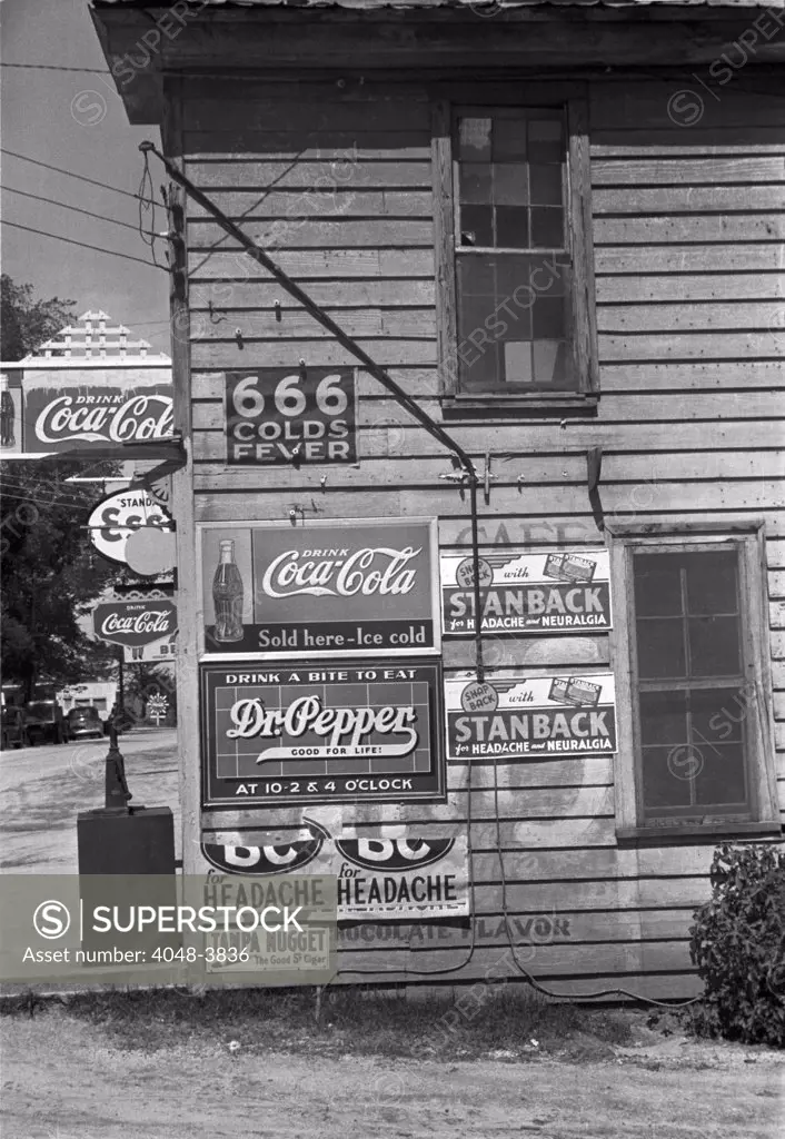 Side of a store, showing advertising signs, including 666 cold medicine, Dr. Pepper, Coca-Cola, Esso Gasoline, Halifax, North Carolina, photograph by John Vachon, April, 1938.