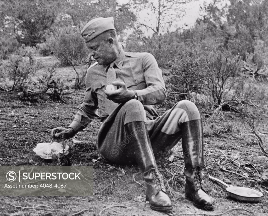World War II, Future President General Dwight D. Eisenhower (1890-1969), stopping for noon mess by the roadside during an inspection tour in Tunisia. The menu is a C ration, and hot. It was kept warm by being packed next to the manifold of the General's car enroute, photograph, 1943.