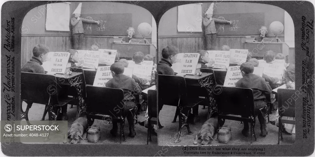 Classroom with children reading various crime stories and boy, wearing dunce cap, at blackboard, original title: 'But, Oh! see what they are studying!', stereo photograph by Underwood & Underwood, 1906.