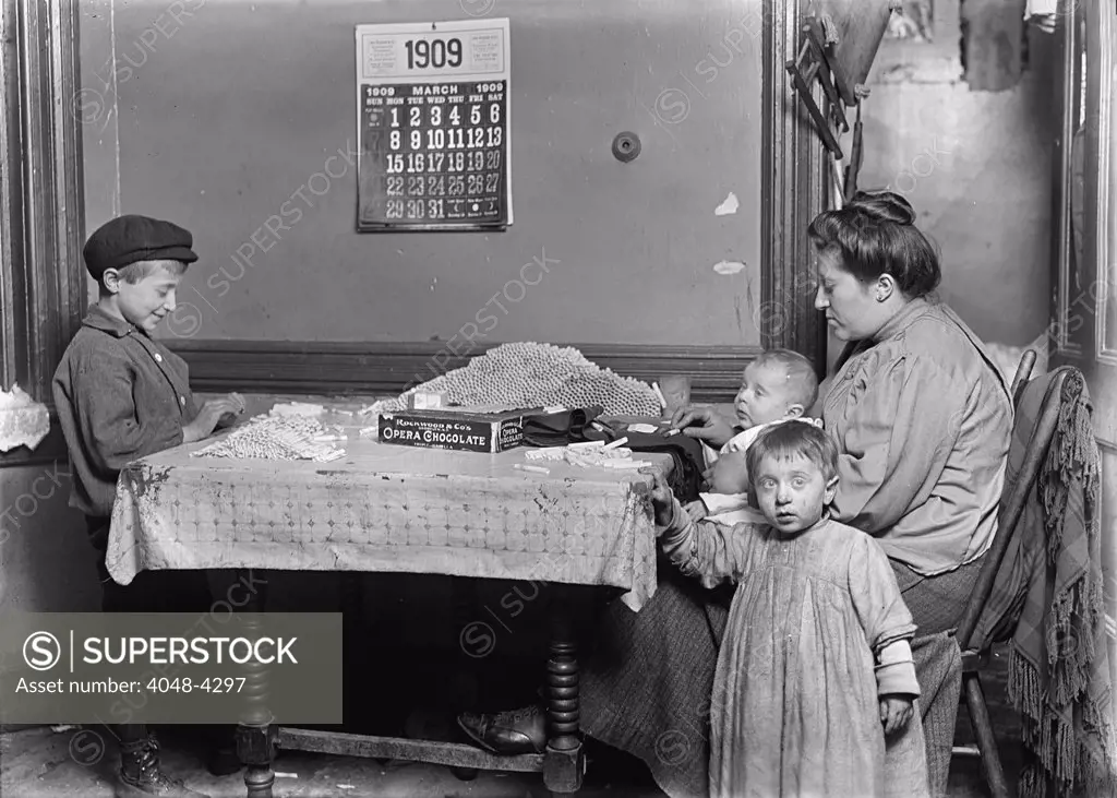 Child labor, Widow & boy rolling papers for cigarettes in a dirty tenement, New York, photograph by Lewis Wickes Hine, March, 1909