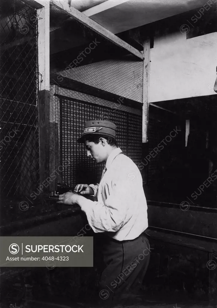 A Postal Telegraph boy learning to send messages during spare moments. Main office, Broadway, New York, photograph by Lewis Wickes Hine, July, 1910