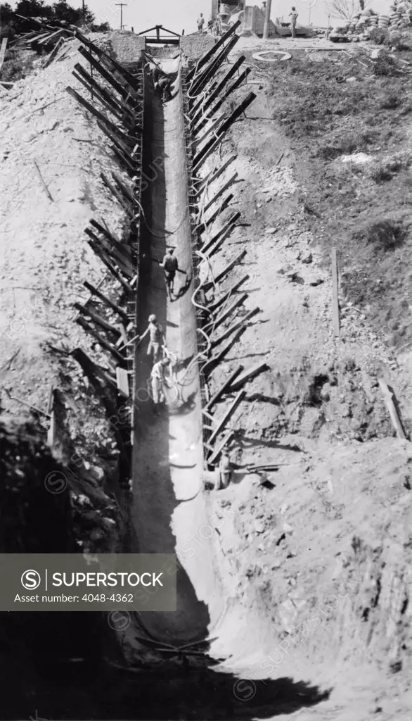 California, California Citrus Heritage Recording Project, view of construction of Gunite invert siphon replacing flume #10 on gage irrigation canal, Riverside County, circa 1930s-1940s.