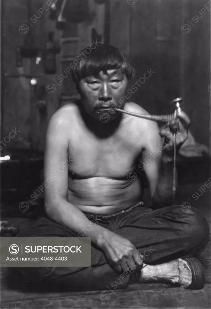Eskimo smoking pipe, photograph by Lomen Bros., 1900-1927