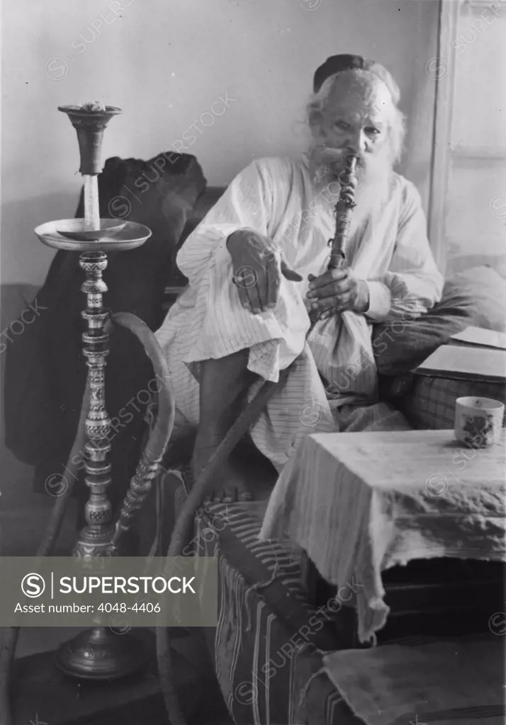 Seated man smoking a nargile, or water pipe, photograph, 1898-1946