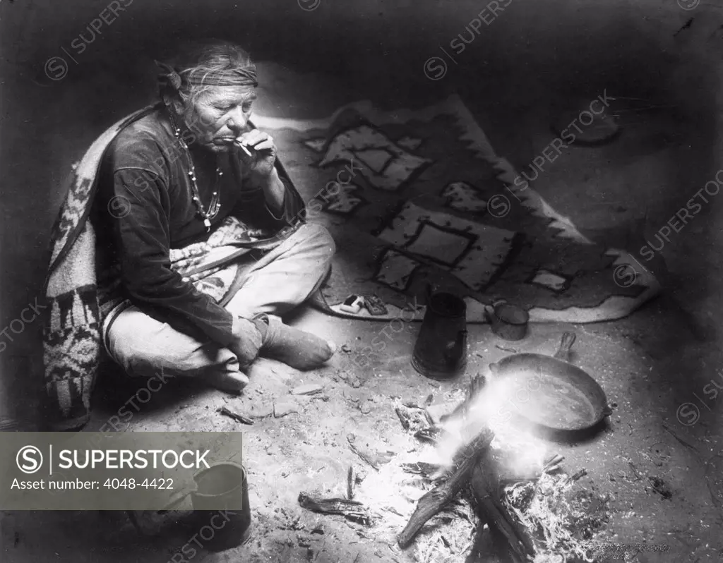 After dinner smoke, Navajo Indian, seated by campfire, smoking cigarette, photograph by William J. Carpenter, 1915