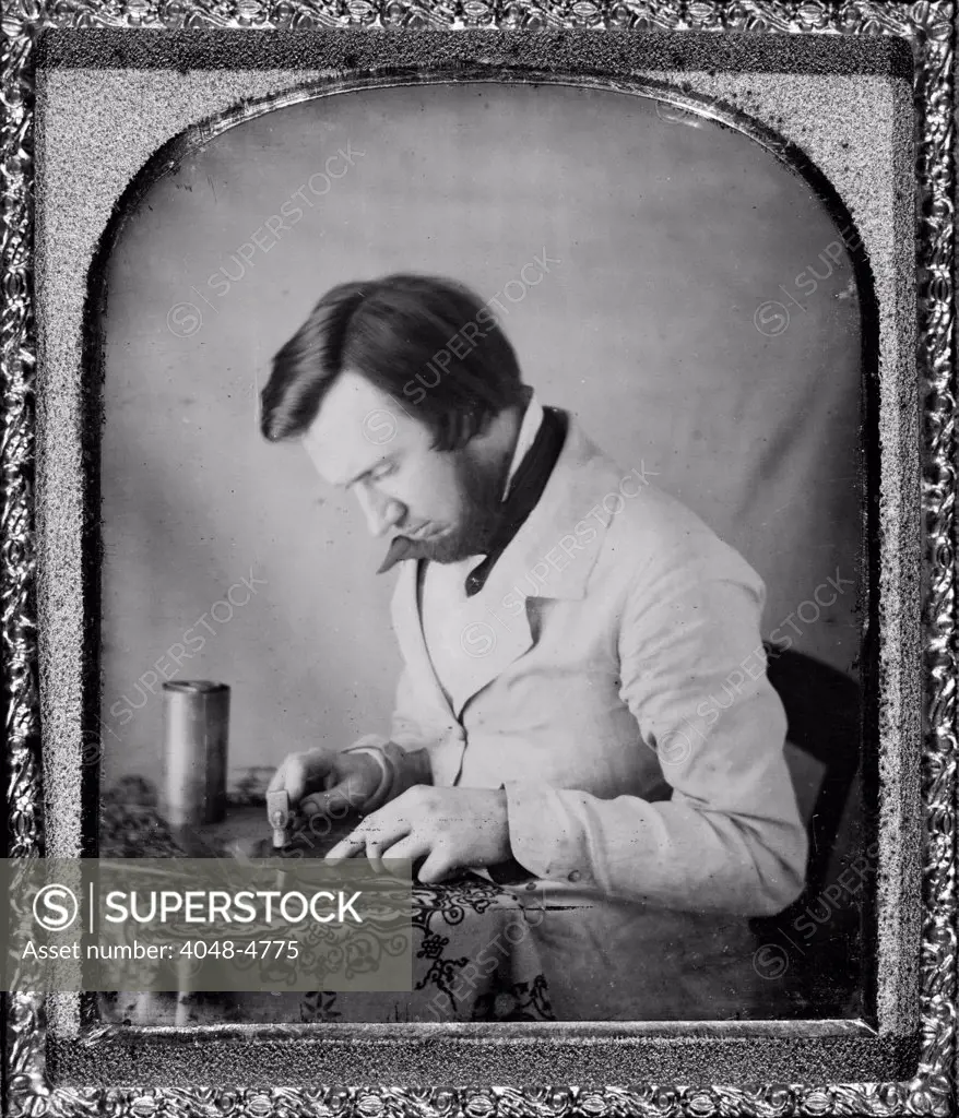 Occupational portrait of a tinworker seated at table with tablecloth, working with a mallet, snips, compass, and metal cylinder. sixth plate daguerreotype ca 1950s