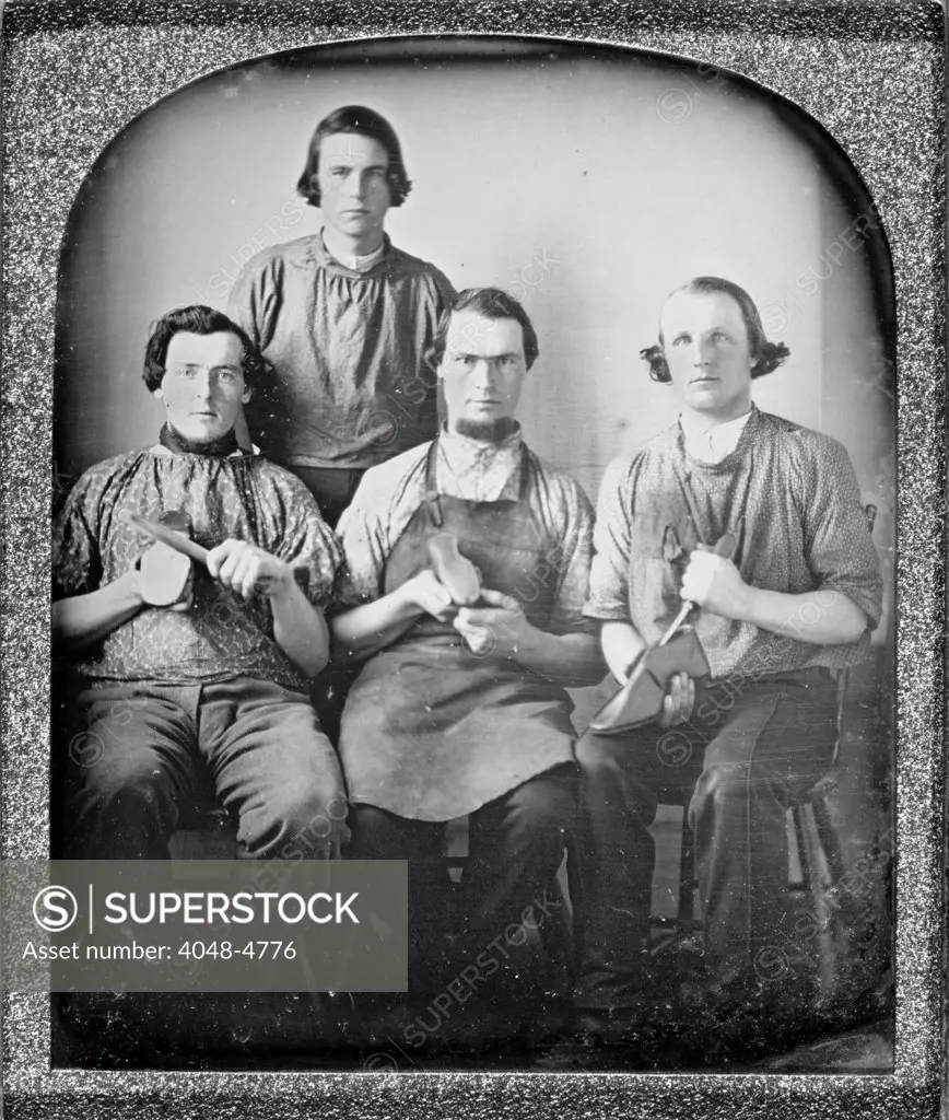 Occupational group portrait of four cobblers, holding shoes and shoe making equipment. sixth plate daguerreotype ca 1840-1860